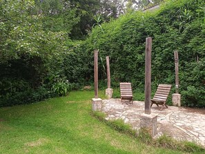 Ein Garten mit zwei hölzernen Bänken und einem Kiesweg.