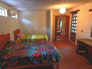 Ein Schlafzimmer mit einem Bett, einer Holzbänkläufe, einer Tür und einem Fenster.