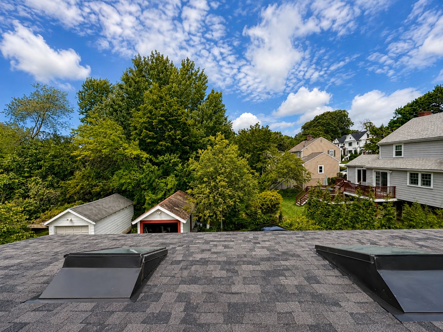 Un quartier résidentiel avec une maison dotée d’un toit en pente et d’un petit garage attenant.