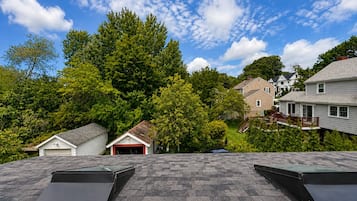 Un quartier résidentiel avec une maison dotée d’un toit en pente et d’un petit garage attenant.