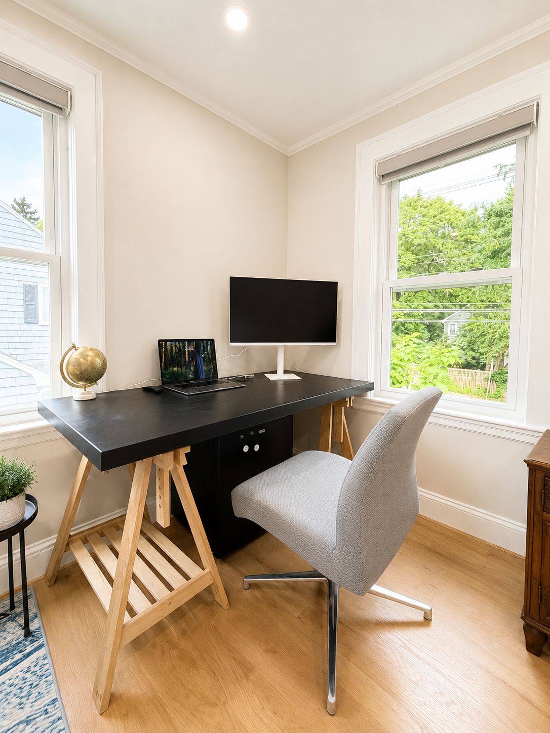 Un espace de bureau moderne comprenant un bureau, une chaise et un écran plat.
