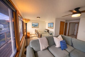 Una sala acogedora con sofá, cama y ventilador de techo.