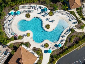 An aerial view of a swimming pool area with multiple seating arrangements and surrounding greenery. - Work, Play and Stay, 3BR, Prime Orlando Location (Orlando)