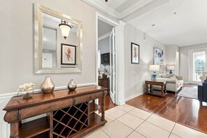 A well-lit hallway with a wooden console table, a mirror, and framed artwork on the walls. - Work, Play and Stay, 3BR, Prime Orlando Location (Orlando)