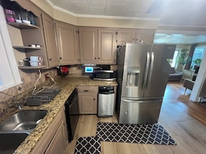 A kitchen with granite countertops, stainless steel appliances, and beige cabinetry.
