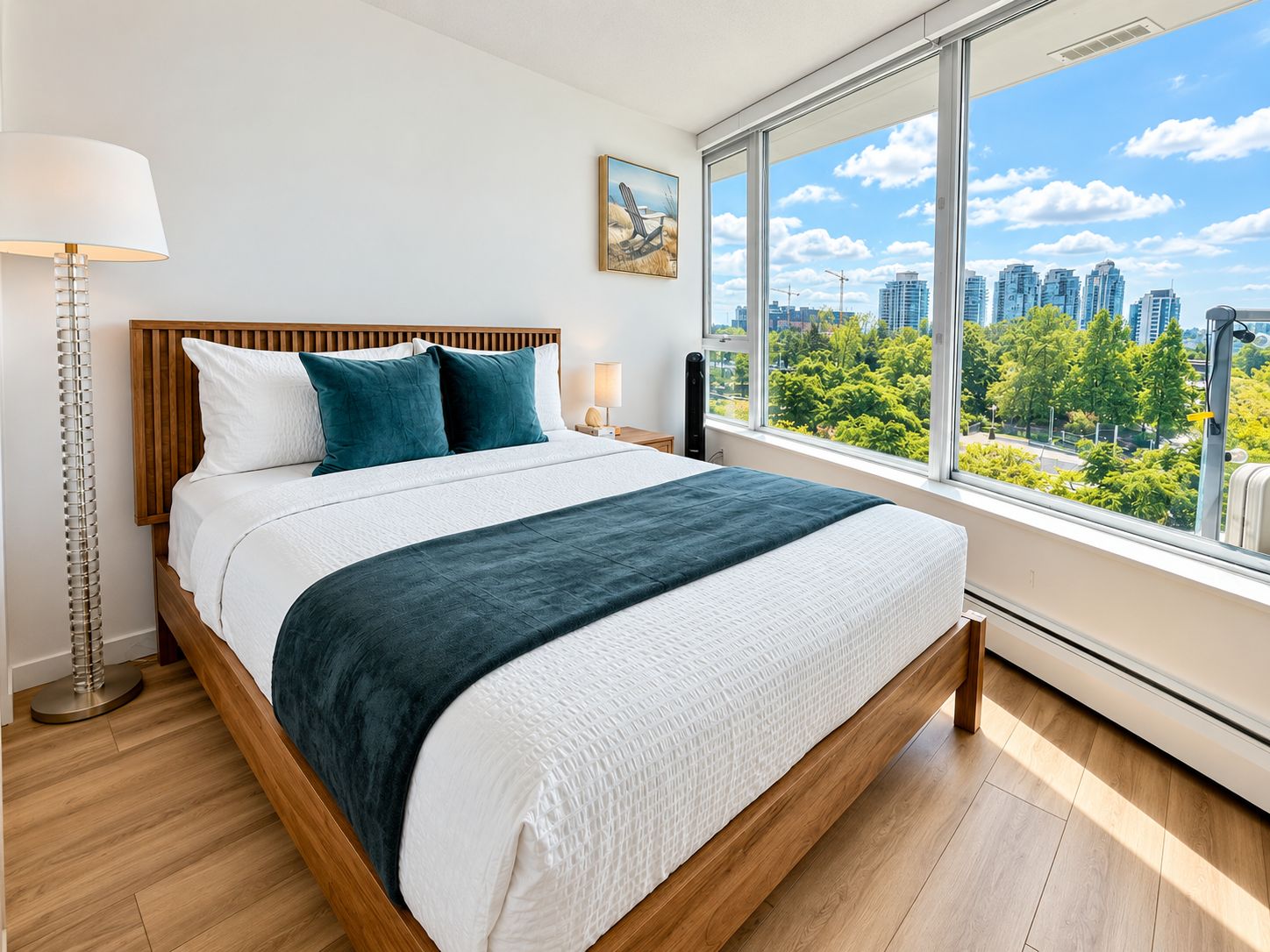 A modern bedroom with a large bed, a view of the city, and a window with blinds.