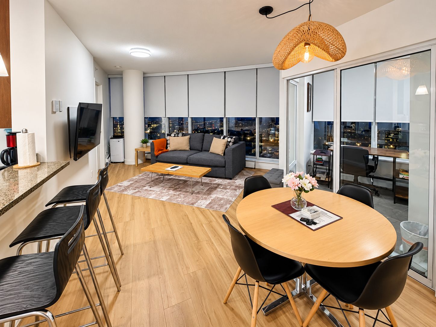 A modern living space with a sofa, coffee table, dining table, and chairs.