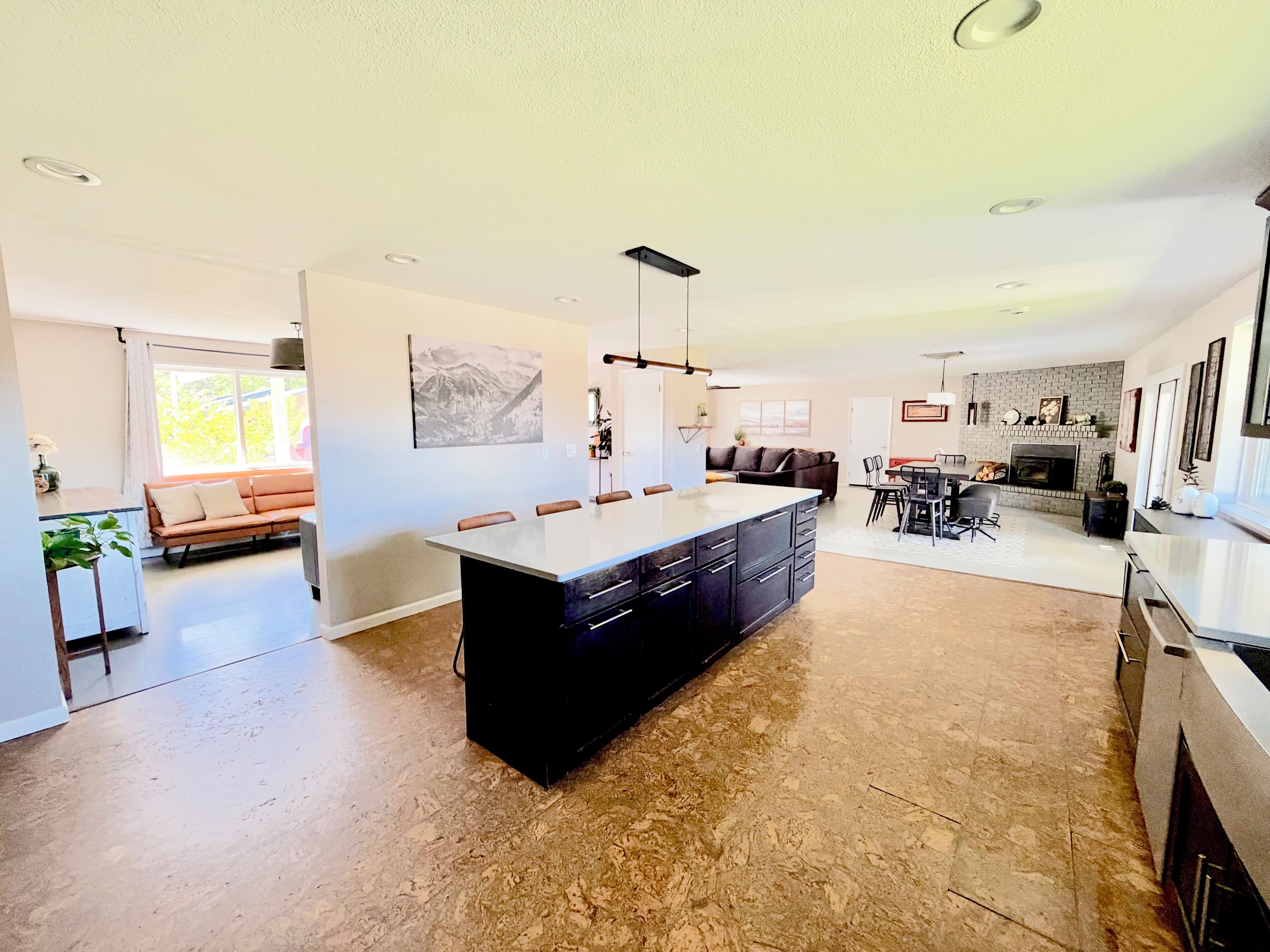 A spacious living area with a large island, a dining table, and a fireplace.