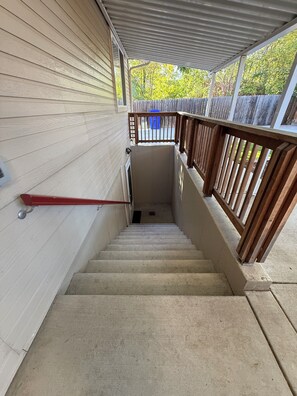 A concrete staircase leading to a covered outdoor area with a wooden railing. - Perfect 2-bedroom apartment in welcoming Loveland for your stay (Loveland)