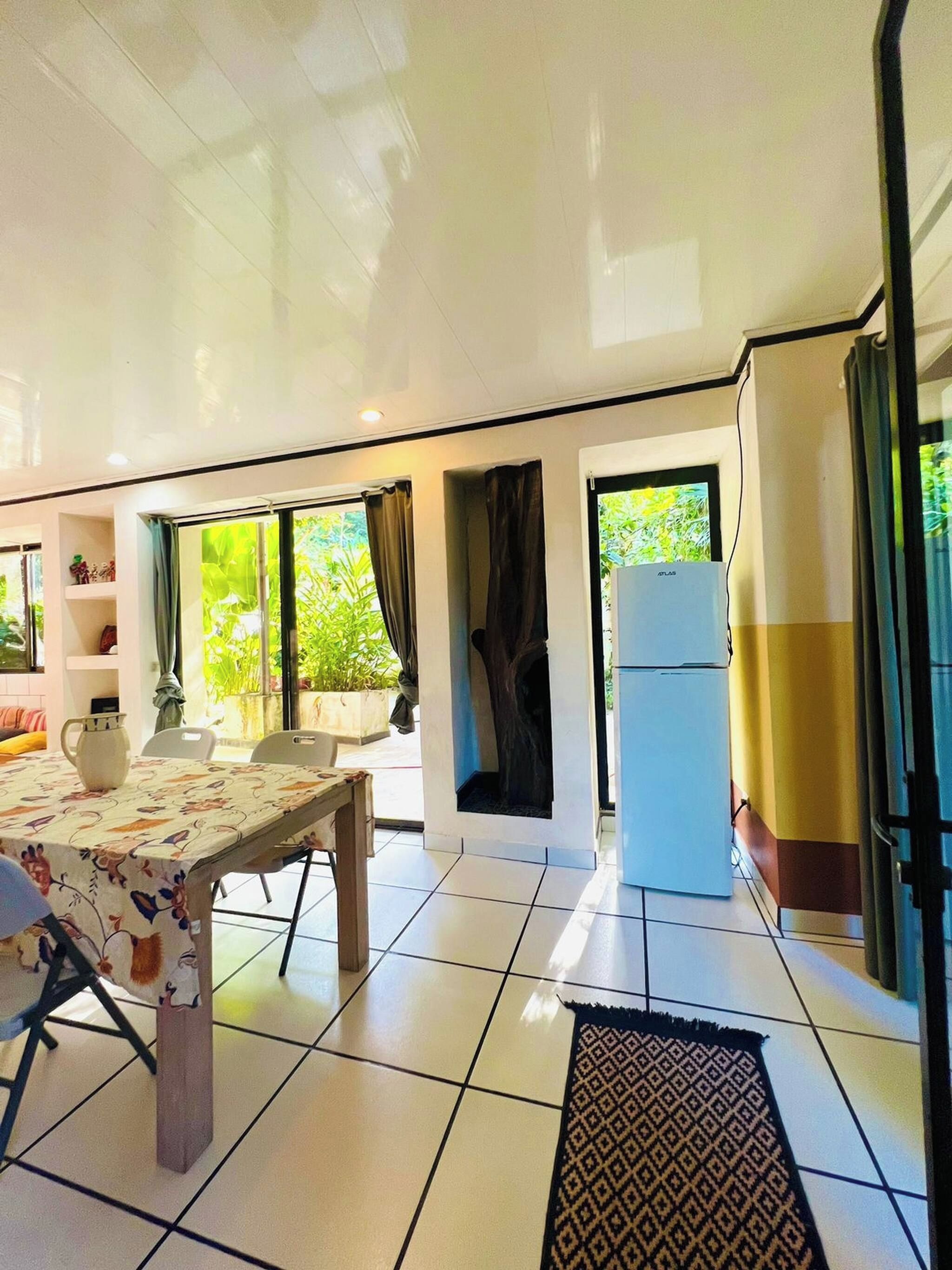 Una cocina moderna con comedor, refrigerador y vistas al exterior.