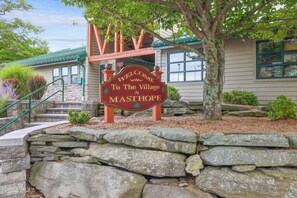 A stone staircase leading to a building with a sign that reads 'WELCOME TO The Village At MASTHOPE.' - Poconos Masthope 4BR Home Ski Big Bear - Lake Pool (Lackawaxen)