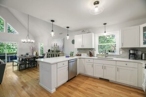 A modern kitchen with white cabinetry, a central island, and pendant lighting. - Poconos Masthope 4BR Home Ski Big Bear - Lake Pool (Lackawaxen)