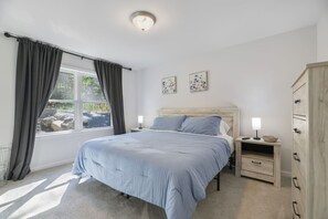 A bedroom with a bed, bedside tables, a wardrobe, and a window with curtains. - Poconos Masthope 4BR Home Ski Big Bear - Lake Pool (Lackawaxen)