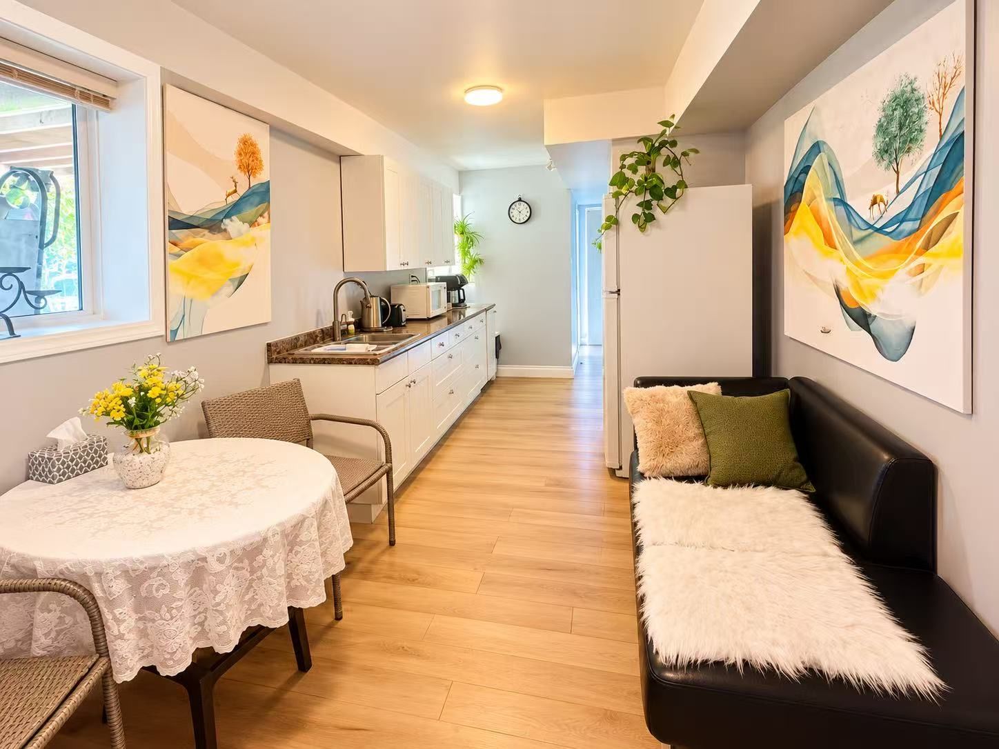 A compact living space with a dining area, a sofa, and a kitchenette.