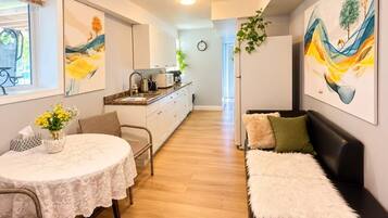 A compact living space with a dining area, a sofa, and a kitchenette.
