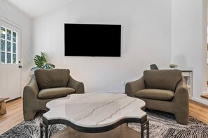 A living room with two sofas facing a flat-screen TV, a marble coffee table, and a patterned rug. - Luxury Spacious Columbia Stay | 3BR • 2BA (Columbia)
