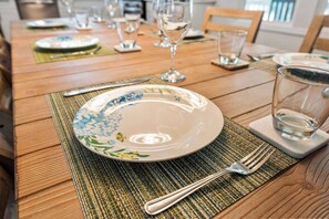 A dining table with a plate, cutlery, and glasses set for a meal. - Luxury Spacious Columbia Stay | 3BR • 2BA (Columbia)