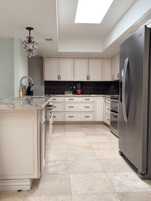 A modern kitchen with a central island, stainless steel appliances, and a black backsplash. - 2-bedroom Wellness/Golf Retreat in Scottsdale (Scottsdale)