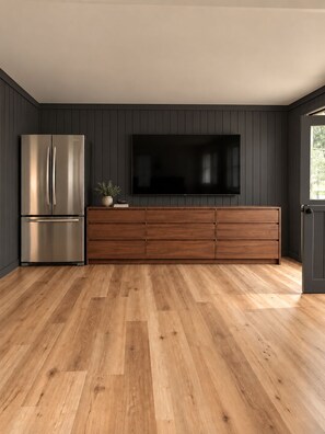 A modern kitchen with a built-in refrigerator, a wooden cabinet, and a flat-screen TV mounted on the wall. - FOUR bedroom FOUR bathroom - HOT TUB! - One entire separate garage en-suite !! (Sunrise Beach)