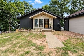 A modern house with a stone facade, a front porch, and a garage. - FOUR bedroom FOUR bathroom - HOT TUB! - One entire separate garage en-suite !! (Sunrise Beach)