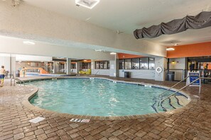 An indoor swimming pool with a tiled edge, a brick floor, and a sign indicating a depth of 3 feet. - Relaxing 3 BR Condo Modern Decor with Pool Access (Myrtle Beach)
