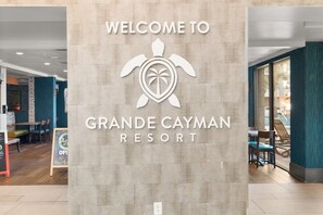 A sign welcoming visitors to Grande Cayman Resort, featuring a turtle logo and the resort's name. - Relaxing 3 BR Condo Modern Decor with Pool Access (Myrtle Beach)