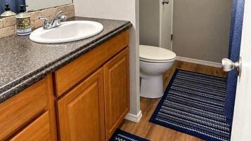A bathroom with a sink, toilet, and shower area.