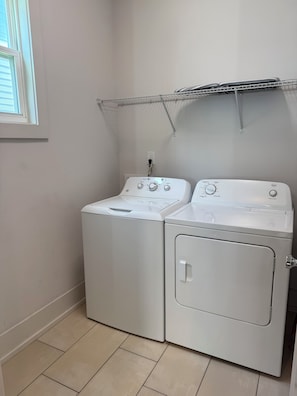 A laundry room with two stacked washers and dryers, a window, and a metal drying rack on the wall. - Spacious 4-bedroom house across from 73 acre park near Uptown Charlotte (Charlotte)