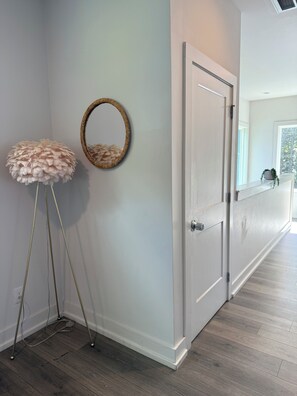 A hallway with a white door, a round mirror, and a fluffy stool. - Spacious 4-bedroom house across from 73 acre park near Uptown Charlotte (Charlotte)
