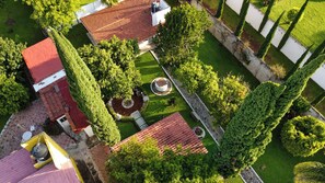 Una propiedad residencial con una casa de techo rojo, un jardín bien cuidado y un camino de acceso pavimentado.