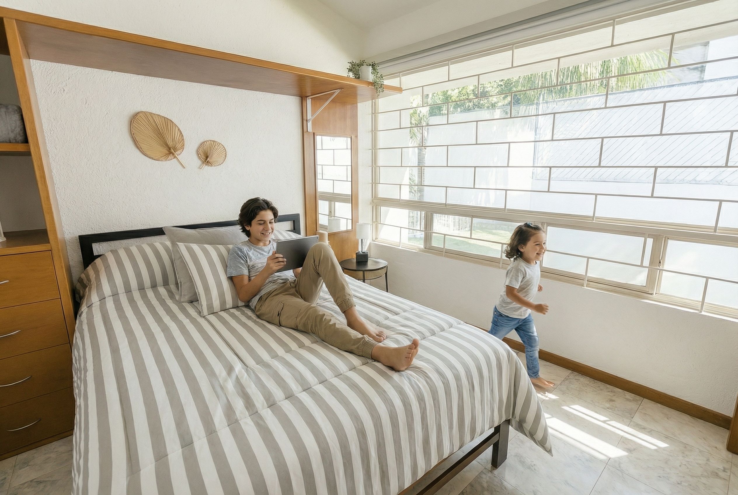 Een slaapkamer met een bed, nachtkastje, raam met uitzicht en een wandplank.