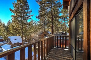 A wooden balcony with a view of snow-covered houses and tall pine trees. - Singing Pines - 4 bed, 4 bath Marla Bay home SLT (Glenbrook)