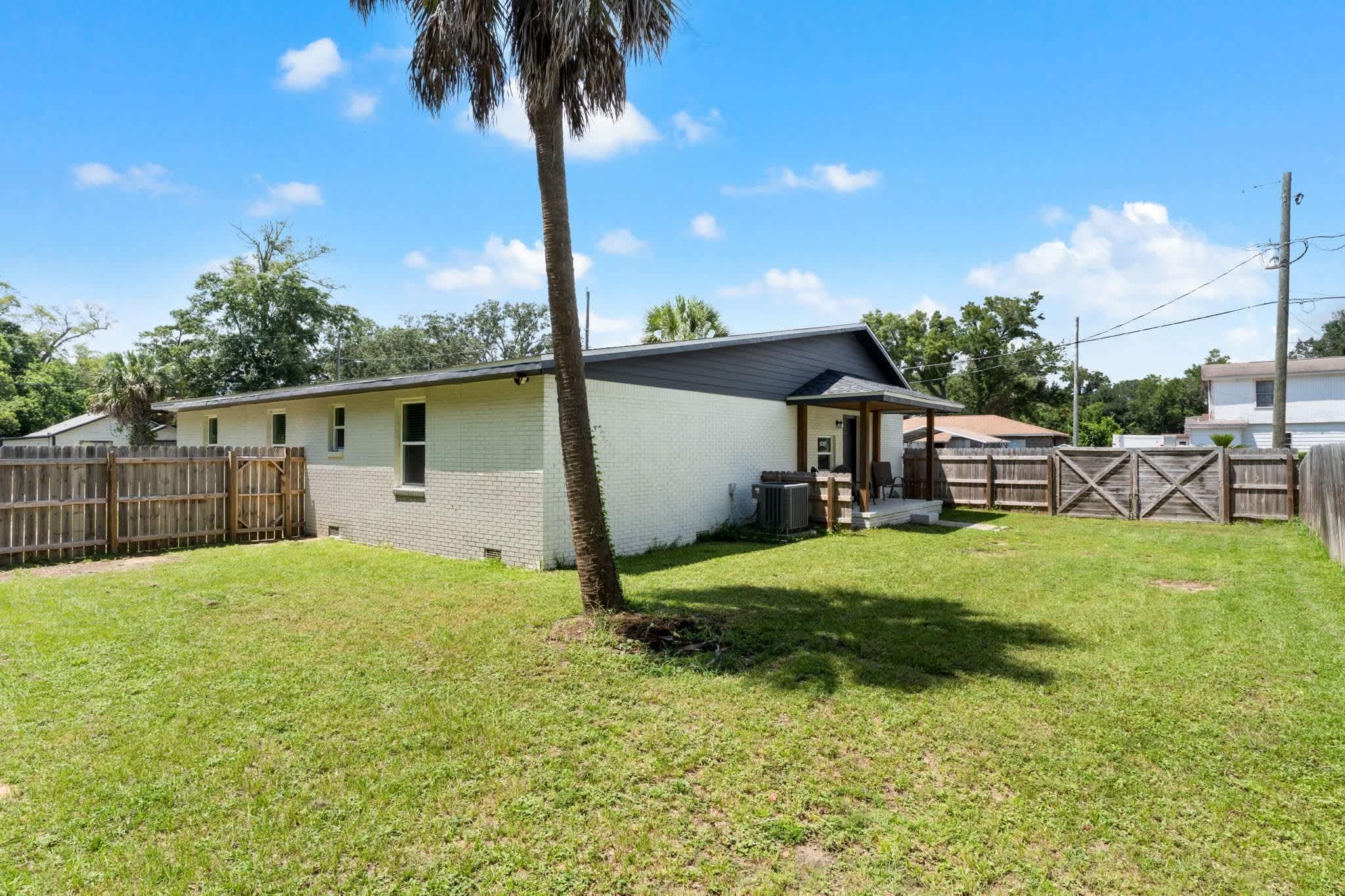 A single-story house with a small front yard and a wooden fence.