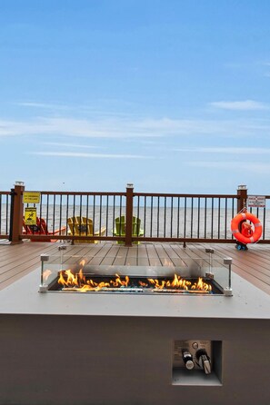 A deck with a fire feature, chairs, and a lifebuoy. - Peaceful Lake Ontario waterfront & sunsets (Lyndonville)