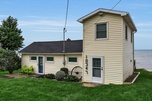 A two-story house with a front porch, a small attached garage, and a visible number '10347' on the side. - Peaceful Lake Ontario waterfront & sunsets (Lyndonville)