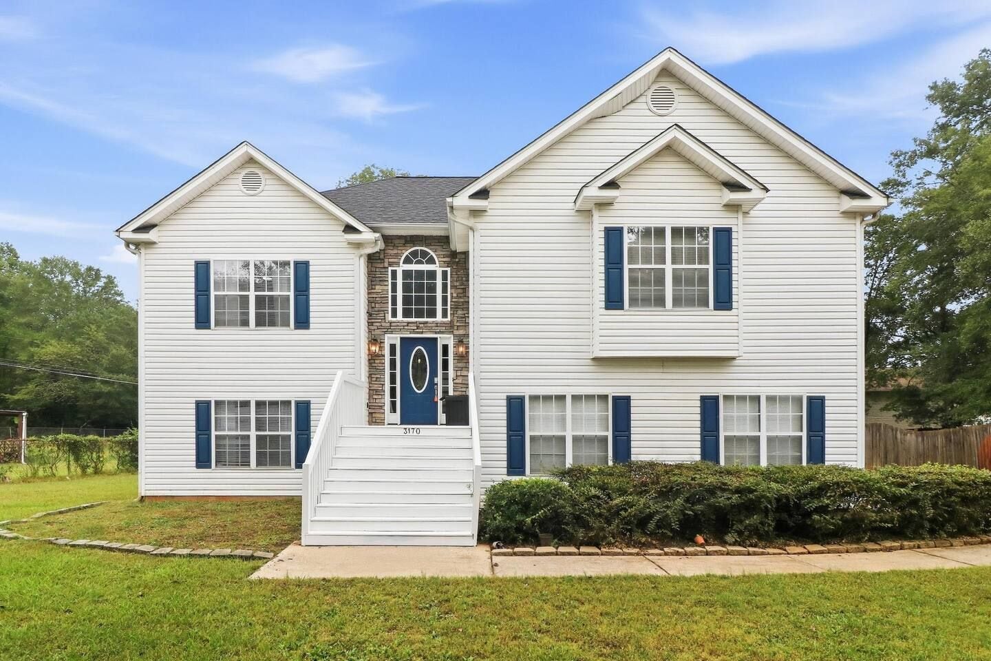 A two-story house with a front porch, a stone entryway, and a number '3170' on the door.