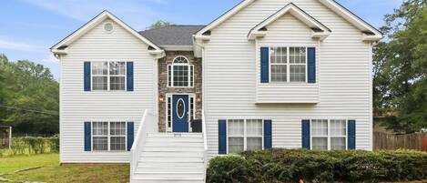 A two-story house with a front porch, a stone entryway, and a number '3170' on the door.