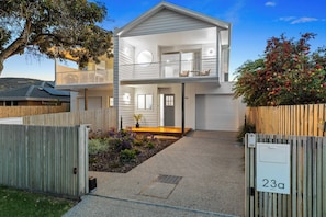 A two-story residential building with a balcony, a front entrance, and a small garden area. - Heated pool, Rosewood Retreat (Rosebud)