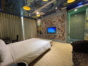 A hotel room with a bed, a television mounted on the wall, and a patterned wallpaper. - 9Th Motel (ChangHua City)