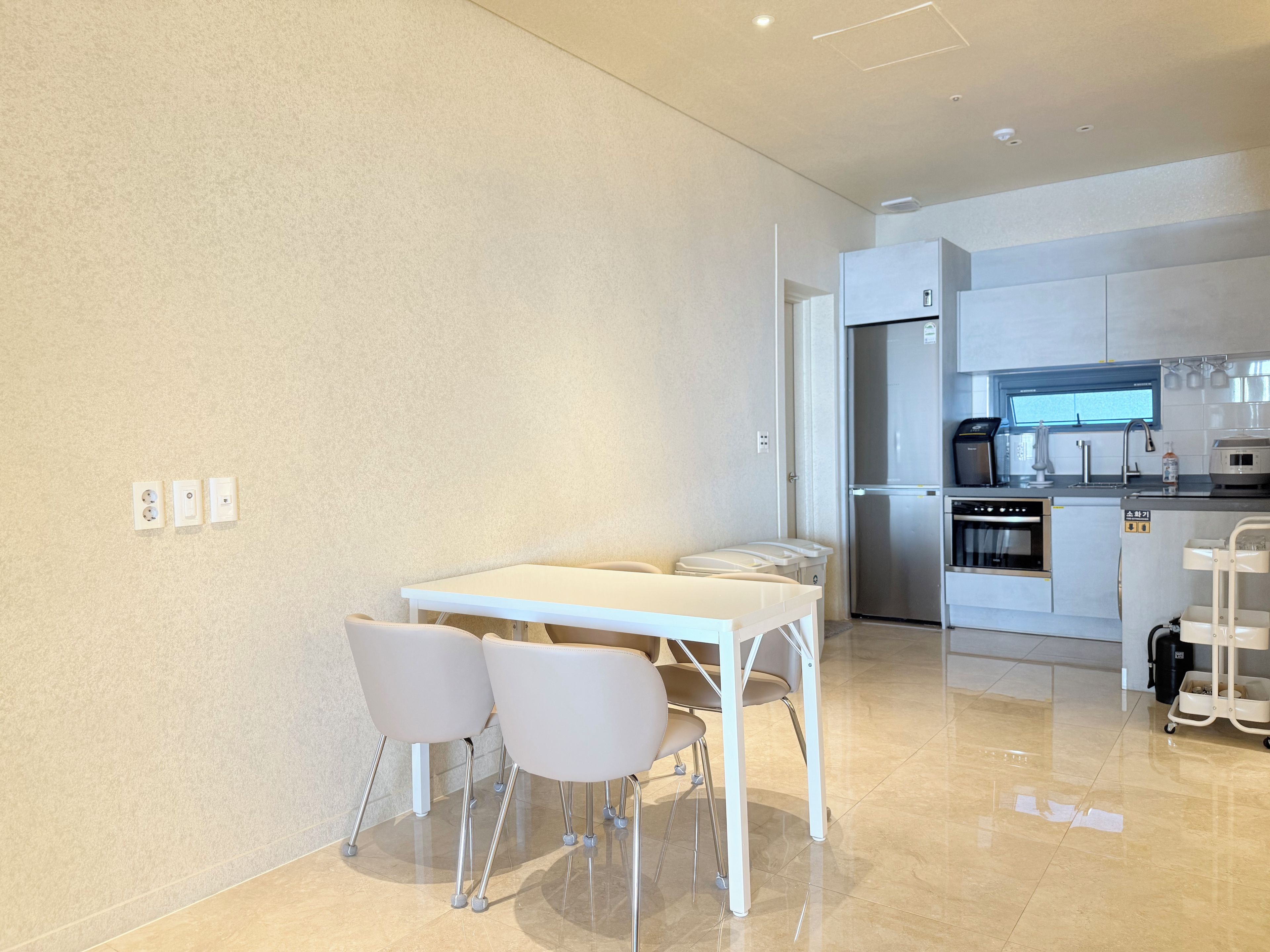 A modern kitchen with a built-in oven, refrigerator, and coffee maker.