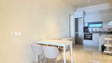 A modern kitchen with a built-in oven, refrigerator, and coffee maker.