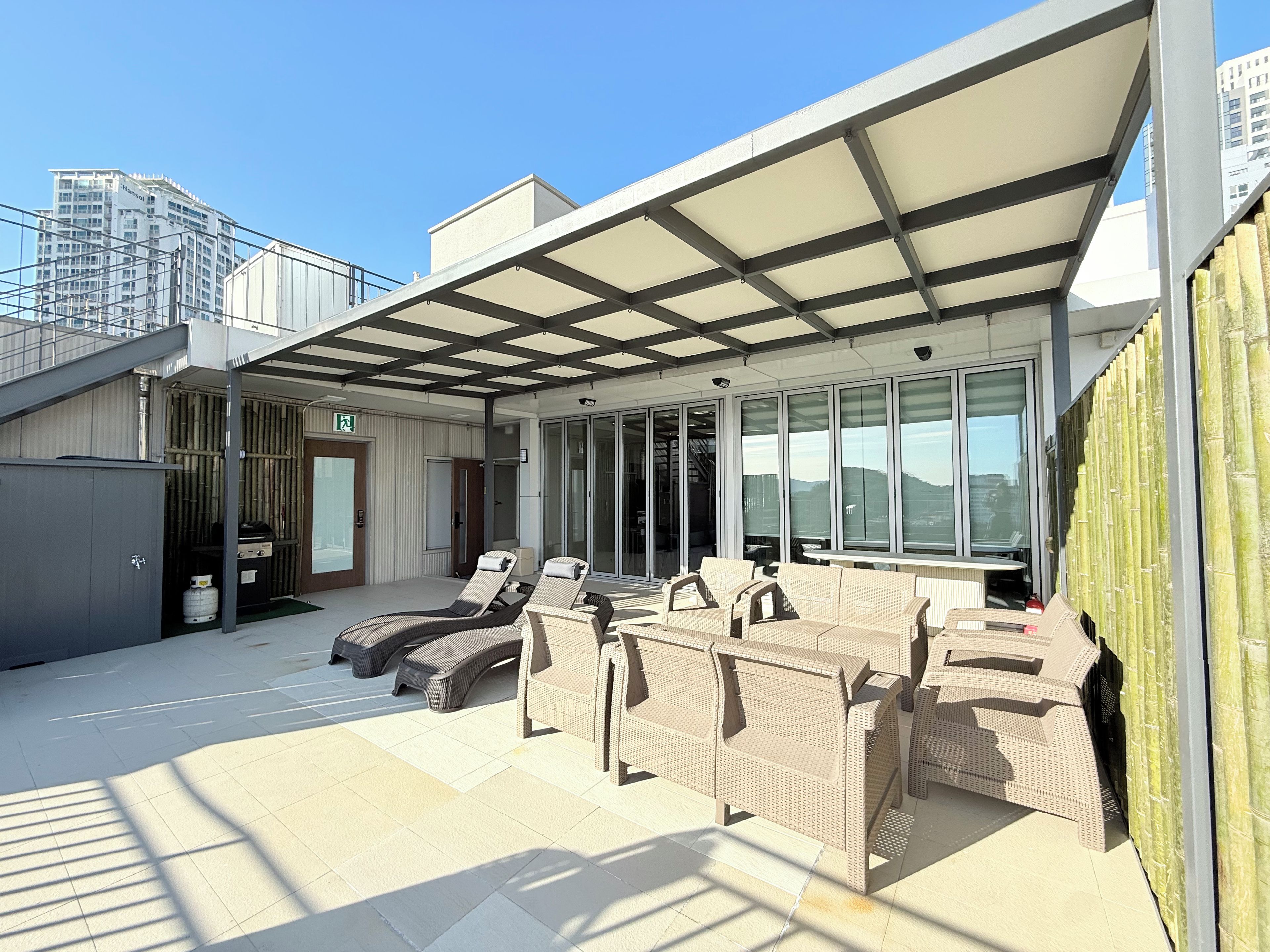 Una terraza en la azotea con mobiliario exterior y una zona cubierta.