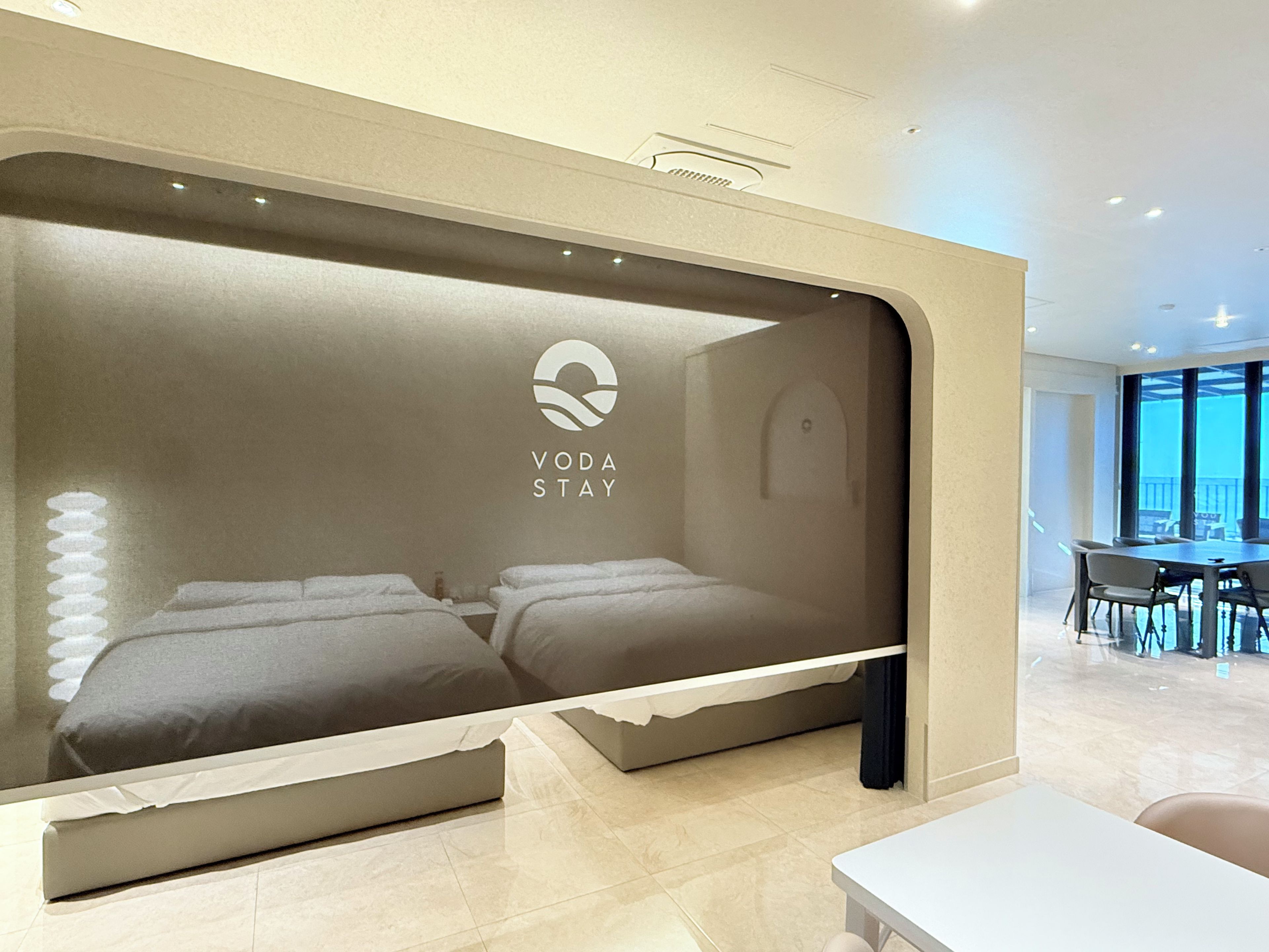 A hotel room with a bed, a desk, and a view of the outside.