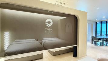 A hotel room with a bed, a desk, and a view of the outside.