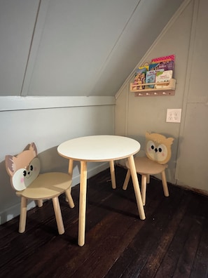 A corner room with a white ceiling, a wooden floor, and two wooden chairs with animal faces. - Rickett's Cozy Cottage in Lopez PA- Pet Friendly (Lopez)