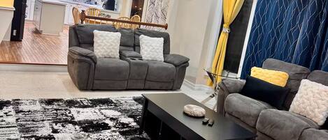 Una sala de estar moderna con un sofá modular, una mesa de centro y una alfombra estampada.