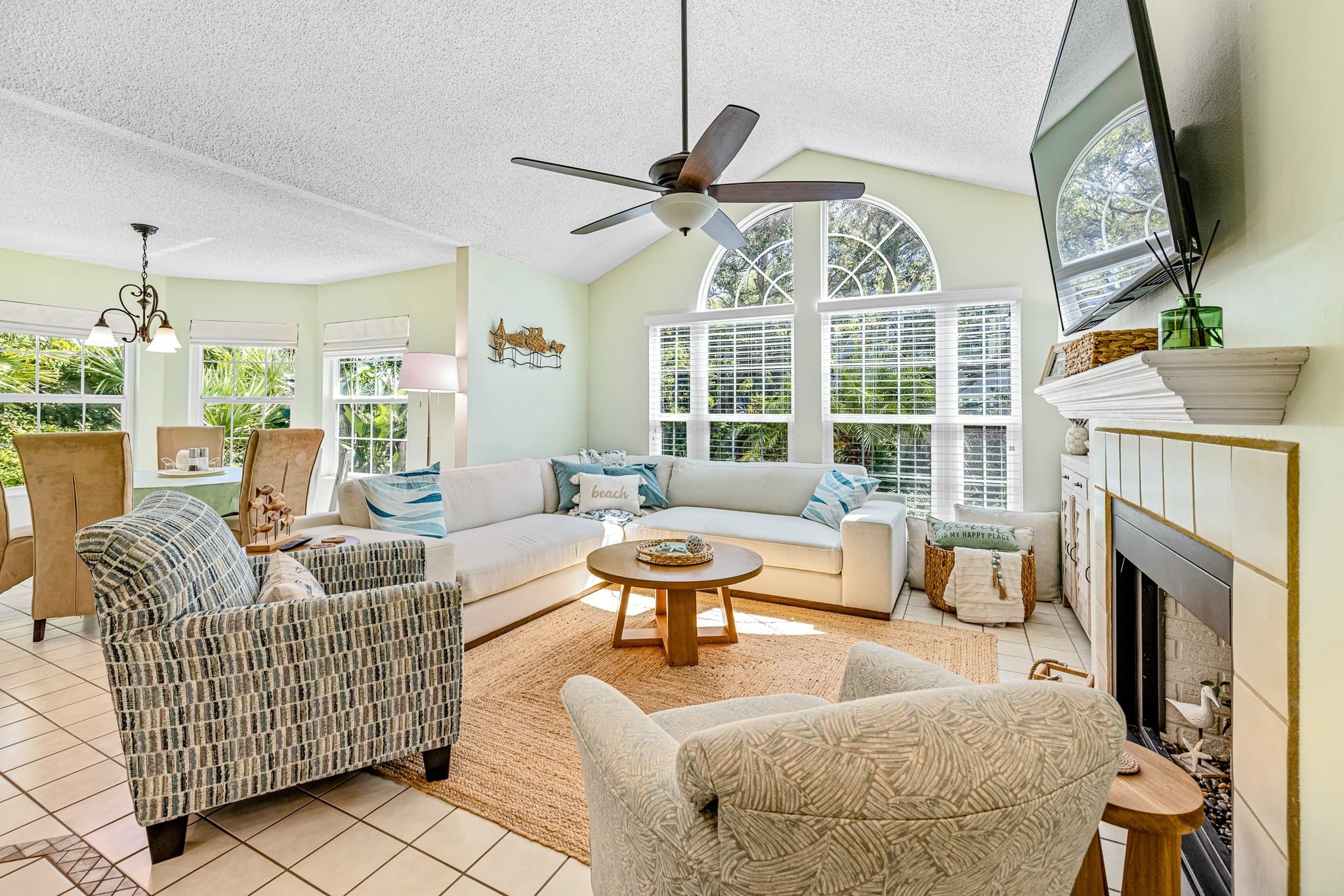 Un salon spacieux comprenant un canapé, des fauteuils, une table basse et une cheminée.