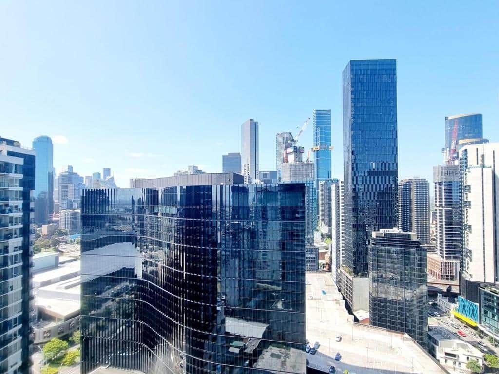Paesaggio urbano con moderni grattacieli, tra cui un imponente grattacielo in vetro.