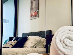 A hotel room with a bed, pillows, a headboard, a window, and a wall-mounted artwork. - Stunning Stay Steps away from Crown w/Free Parking (Southbank)