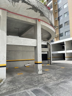 Eine mehrgeschossige Parkgarage mit Betonstützen und gelben Markierungen, die die Parkplätze abgrenzen.